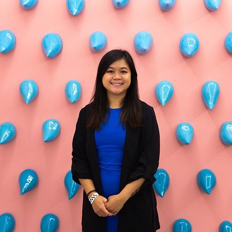 Woman standing in front of pink and blue wall